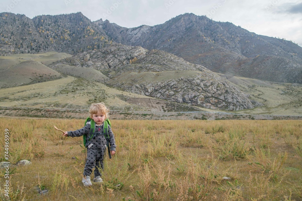 baby in the mountains with a backpack, children's travel, children and mountains, growing up in a natural environment.