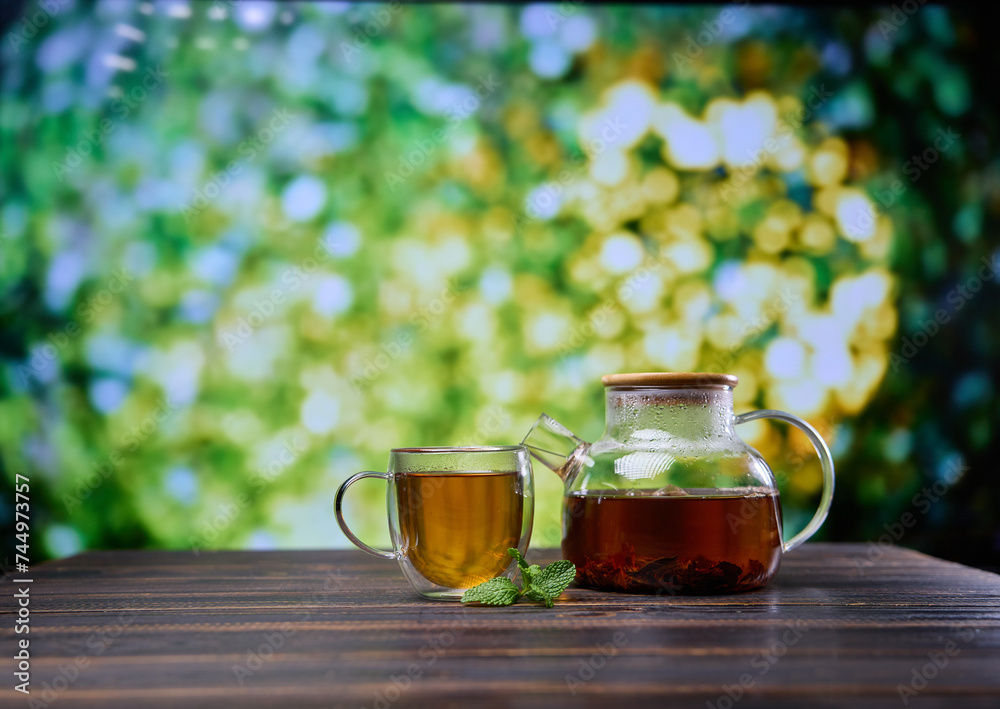 natural organic herbal tea in glass teapot and cup on a wooden table natural organic herbal tea in glass teapot and cup on a wooden table