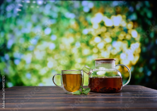 natural organic herbal tea in glass teapot and cup on a wooden table