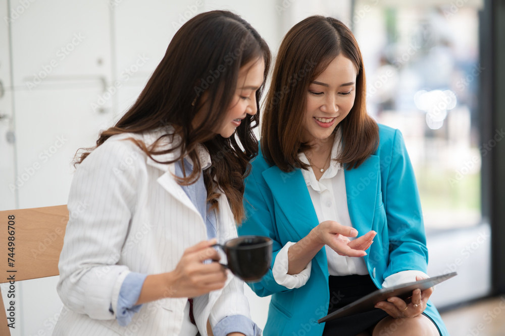 ฺAsia Businesswoman sitting and working using laptop to chat with customers online in office ฺAsia Businesswoman sitting and working using laptop to chat with customers online in office