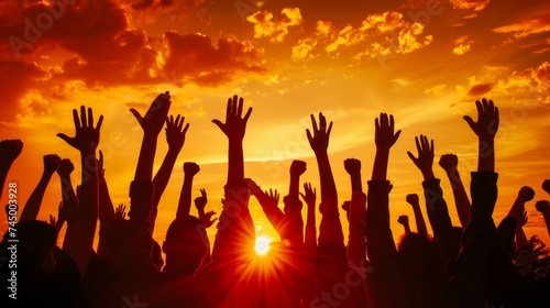 Vibrant sunset backdrop with uplifted hands, depicting celebration or concert enthusiasm at dusk