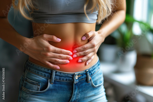 Menstrual pain, woman with stomachache suffering from pms at home, endometriosis, cystitis and other diseases of the urinary system, painful area highlighted in red photo
