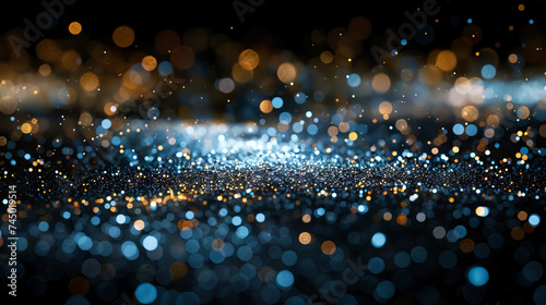 Abstract glittering white, blue and golden particles against a black background