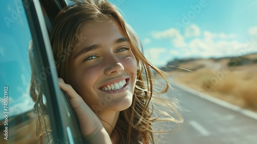 Young beautiful smiling woman looking through the car window.