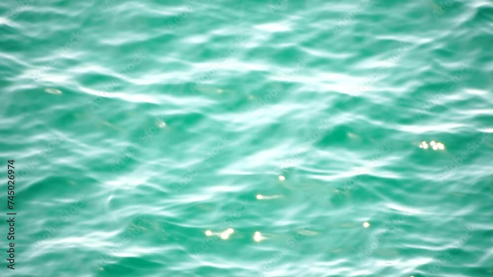 Sea water surface. Aerial view on clear azure sea water. Sun glare. Abstract nautical summer ocean nature. Holiday, vacation and travel concept. Nobody. Slow motion. Weather and climate change Sea water surface. Aerial view on clear azure sea water. Sun glare. Abstract nautical summer ocean nature. Holiday, vacation and travel concept. Nobody. Slow motion. Weather and climate change