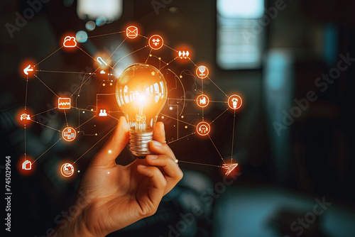 A hand holds a light bulb with business digital marketing innovation technology icons on a network in the background