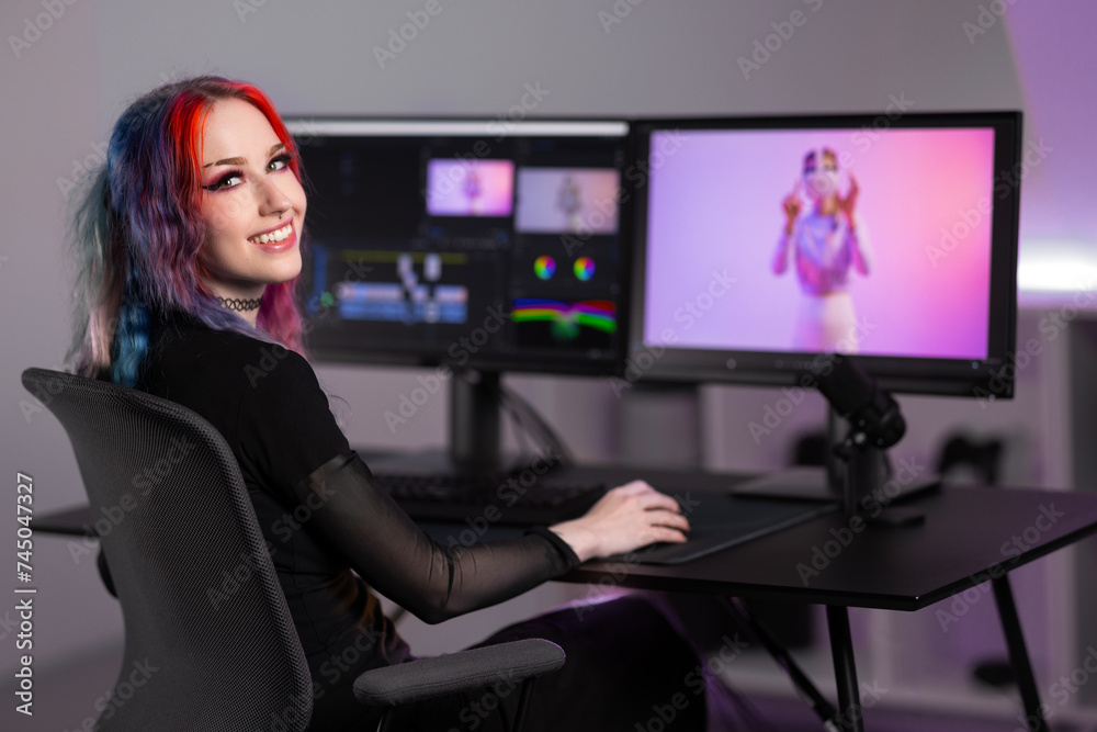 Smiling professional creative digital artist editing video at work in minimalistic office space Smiling professional creative digital artist editing video at work in minimalistic office space