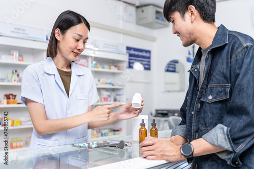 Beautiful asian female pharmacist analyzing about customer symptoms for discussion of the medicine property effect and customer buying pill under prescription order.
