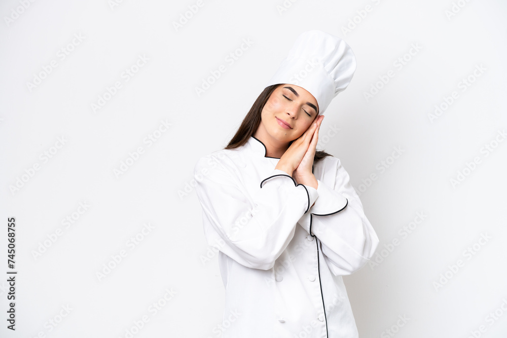 Young Brazilian chef woman isolated on white background making sleep gesture in dorable expression Young Brazilian chef woman isolated on white background making sleep gesture in dorable expression