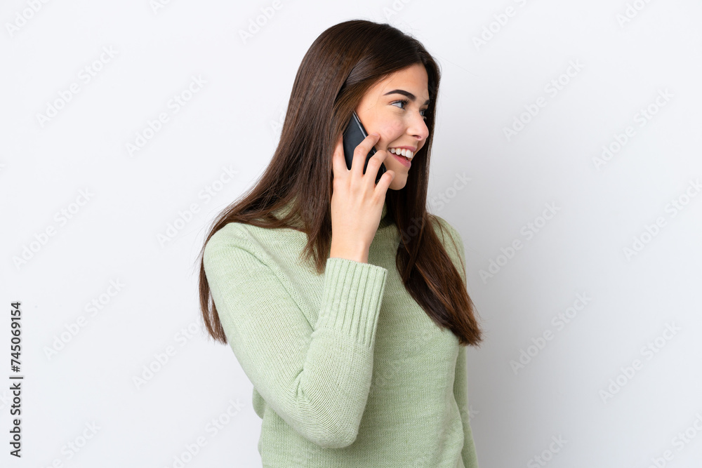 Young Brazilian woman isolated on white background keeping a conversation with the mobile phone with someone Young Brazilian woman isolated on white background keeping a conversation with the mobile phone with someone