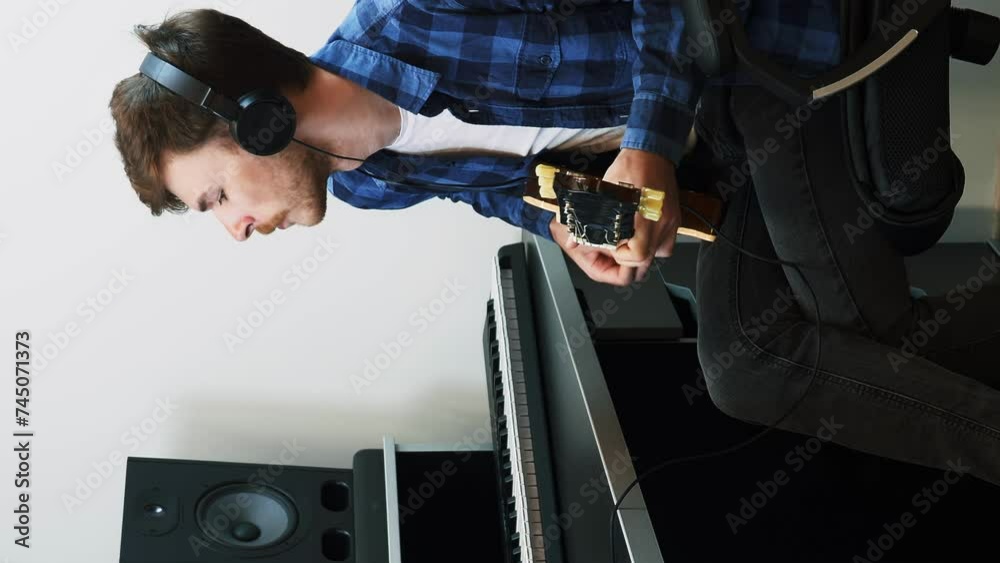Guitarist playing on electric guitar in home music studio. Vertical video Guitarist playing on electric guitar in home music studio. Vertical video