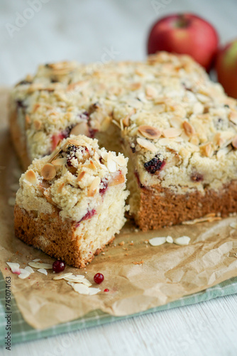 Home made coffee cake with apples with cramb topping and almond slices on crafte background close up selective focus