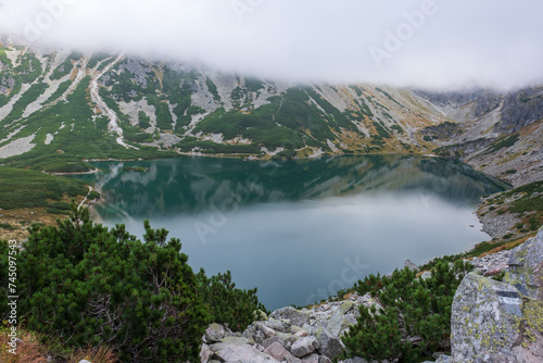 View down towards the clear, reflective water of Czarny Staw Gasienicowy Lake in Poland's Tatra National Park