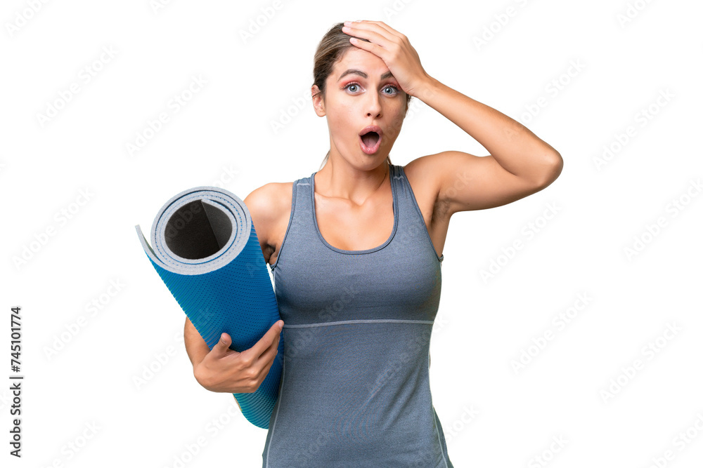 Pretty Young Uruguayan sport woman going to yoga classes while holding a mat over isolated background doing surprise gesture while looking to the side Pretty Young Uruguayan sport woman going to yoga classes while holding a mat over isolated background doing surprise gesture while looking to the side
