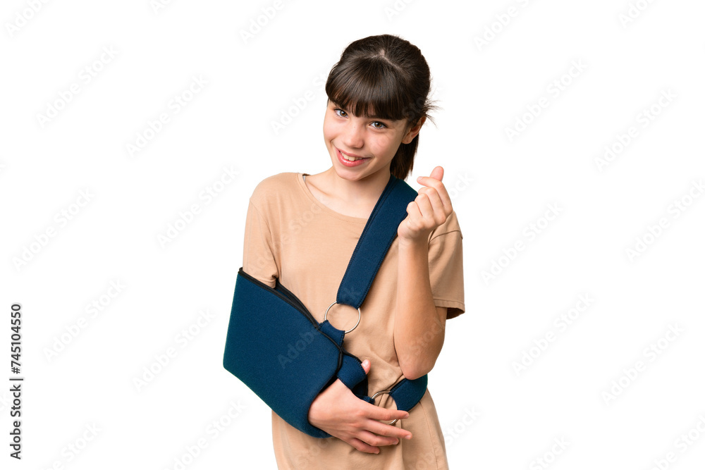 Little caucasian girl with broken arm and wearing a sling over isolated background making money gesture Little caucasian girl with broken arm and wearing a sling over isolated background making money gesture
