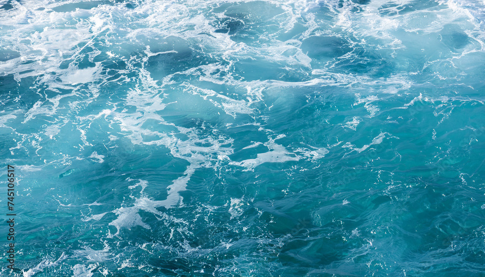 Background shot of aqua sea water surface with foam and copy space