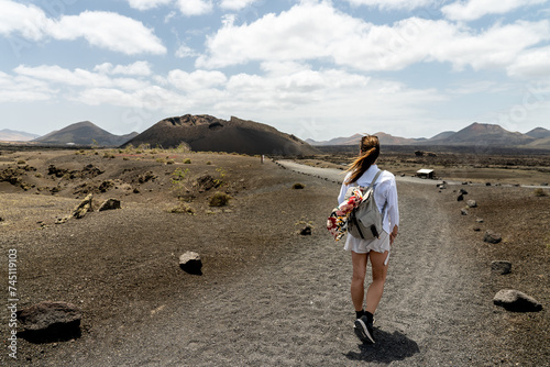 Adventurous woman walking towards the crater of a volcano. Lanzarote