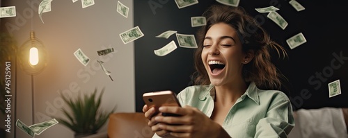 Beautiful young woman is lucky while using smartphone. Winning money concept