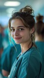 A young nursing student in scrubs smiles for the camera.