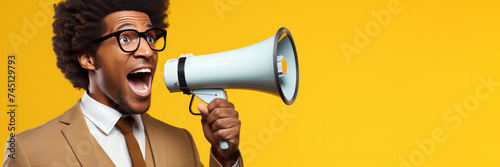 young shocked black man screams into megaphone on solid yellow background, banner with copyspace