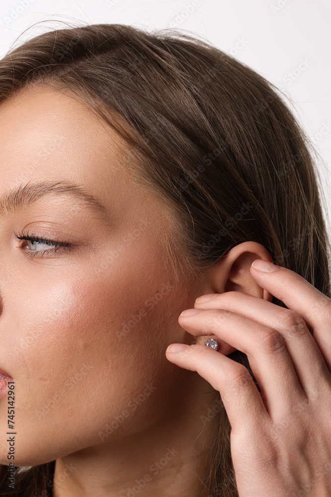 Beautiful young girl with fresh healthy skin. Woman advertise ear-rings. White background. Earrings closeup. Blond european woman with long hair with big lips, pretty smile. Cosmetology, scincare. Beautiful young girl with fresh healthy skin. Woman advertise ear-rings. White background. Earrings closeup. Blond european woman with long hair with big lips, pretty smile. Cosmetology, scincare.