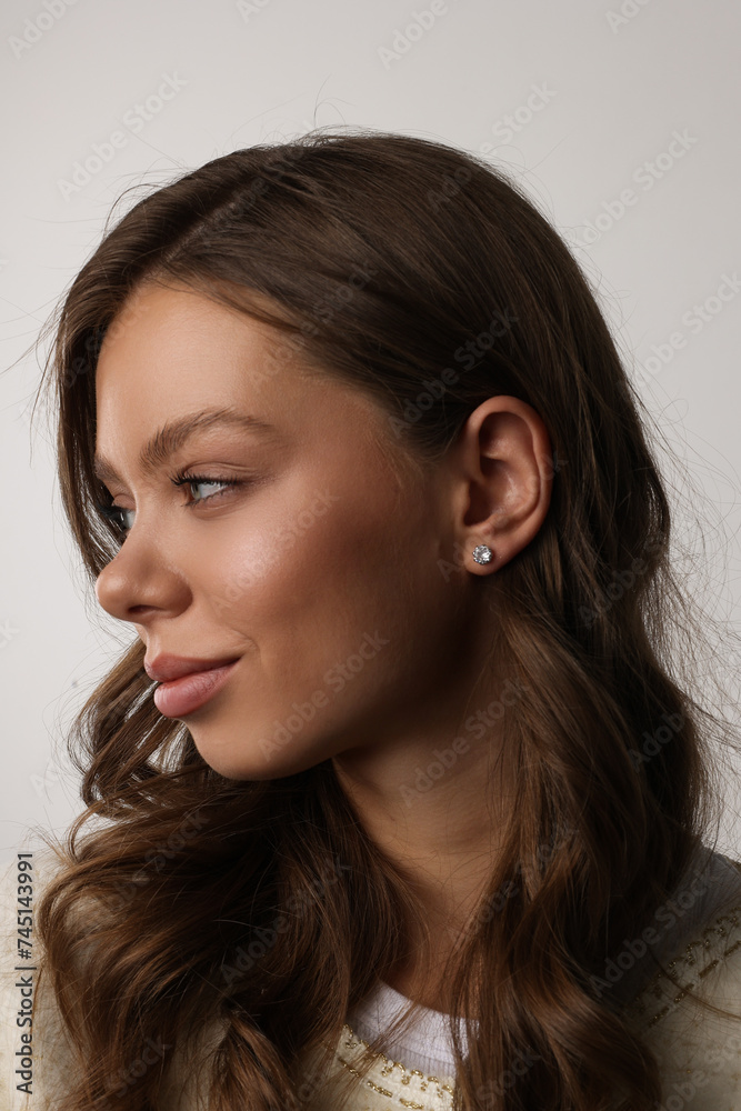 Beautiful young girl with fresh healthy skin. Woman advertise ear-rings. White background. Earrings closeup. Blond european woman with long hair with big lips, pretty smile. Cosmetology, scincare. Beautiful young girl with fresh healthy skin. Woman advertise ear-rings. White background. Earrings closeup. Blond european woman with long hair with big lips, pretty smile. Cosmetology, scincare.