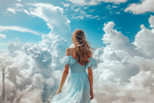 молодая женщина в голубом платье среди кучевых облаков на фоне голубого неба