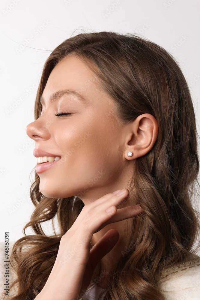 Beautiful young girl with fresh healthy skin. Woman advertise ear-rings. White background. Earrings closeup. Blond european woman with long hair with big lips, pretty smile. Cosmetology, scincare Beautiful young girl with fresh healthy skin. Woman advertise ear-rings. White background. Earrings closeup. Blond european woman with long hair with big lips, pretty smile. Cosmetology, scincare