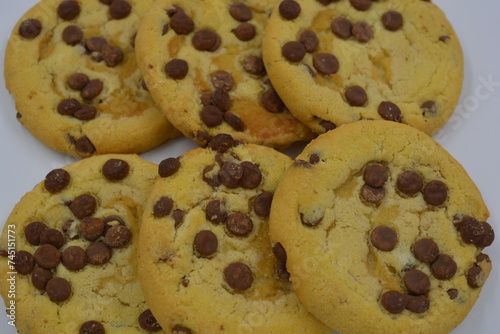 Sweets, delicious, large cookies with small pieces of milk chocolate arranged on a white background.