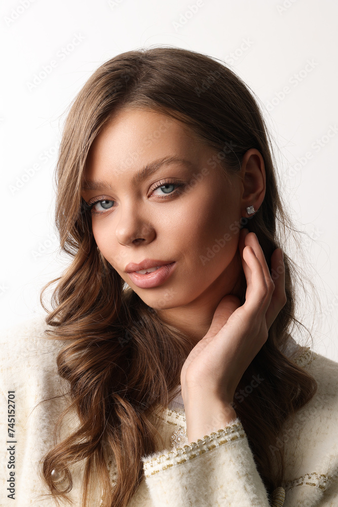 Beautiful young girl with fresh healthy skin. Woman advertise ear-rings. White background. Earrings closeup. Blond european woman with long hair with big lips, pretty smile. Cosmetology, scincare