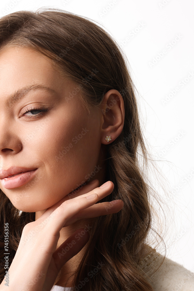 Obraz premium Beautiful young girl with fresh healthy skin. Woman advertise ear-rings. White background. Earrings closeup. Blond european woman with long hair with big lips, pretty smile. Cosmetology, scincare