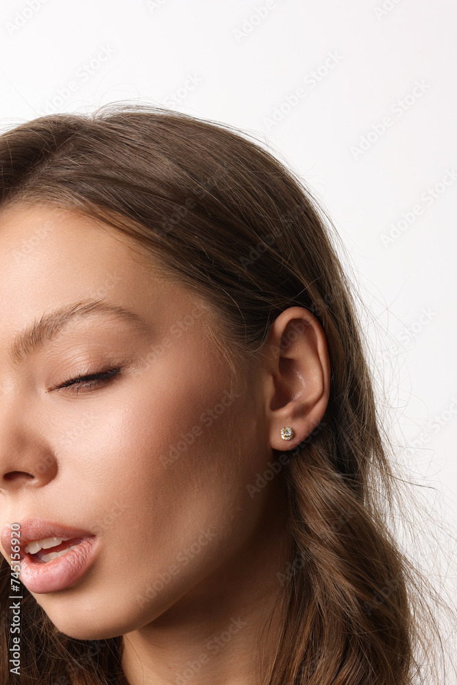 Beautiful young girl with fresh healthy skin. Woman advertise ear-rings. White background. Earrings closeup. Blond european woman with long hair with big lips, pretty smile. Cosmetology, scincare Beautiful young girl with fresh healthy skin. Woman advertise ear-rings. White background. Earrings closeup. Blond european woman with long hair with big lips, pretty smile. Cosmetology, scincare