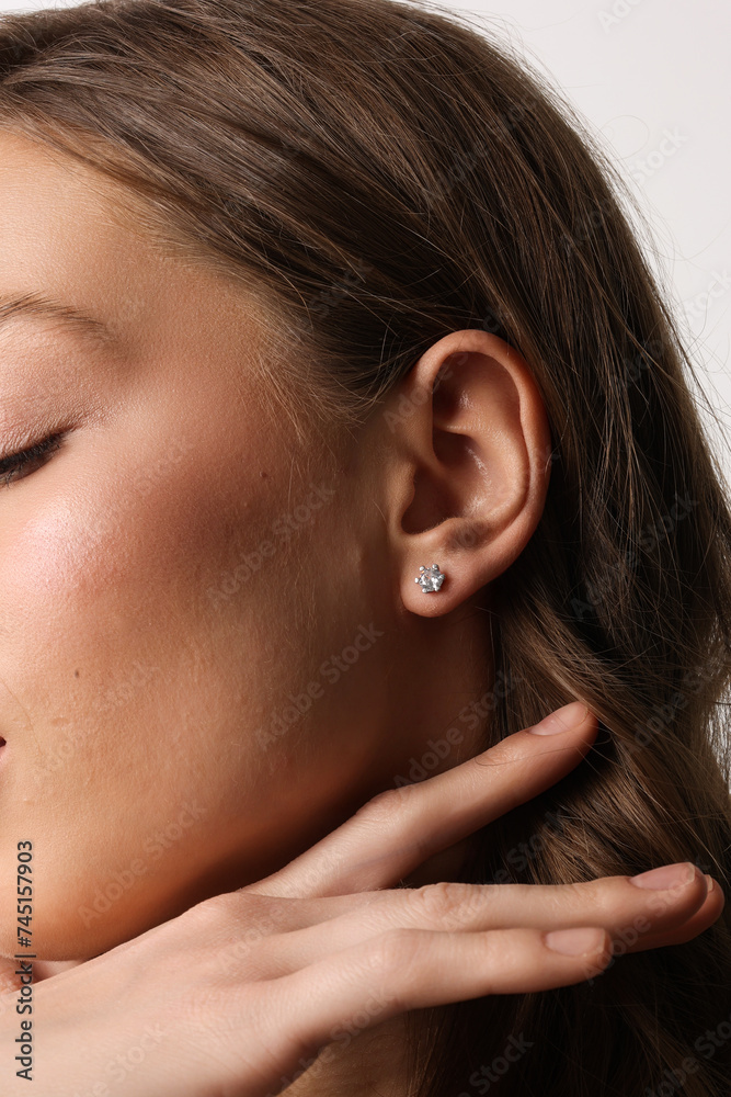 Beautiful young girl with fresh healthy skin. Woman advertise ear-rings. White background. Earrings closeup. Blond european woman with long hair with big lips, pretty smile. Cosmetology, scincare Beautiful young girl with fresh healthy skin. Woman advertise ear-rings. White background. Earrings closeup. Blond european woman with long hair with big lips, pretty smile. Cosmetology, scincare