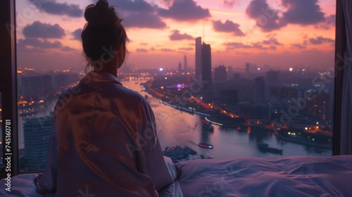 Serene Cityscape View from a High-Rise as a Woman Contemplates the Urban Twilight from Her Window