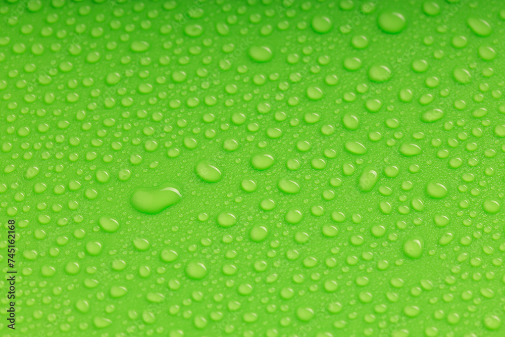 water droplets of various sizes on a green surface