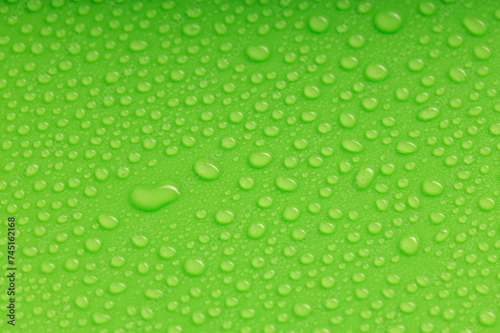 water droplets of various sizes on a green surface water droplets of various sizes on a green surface