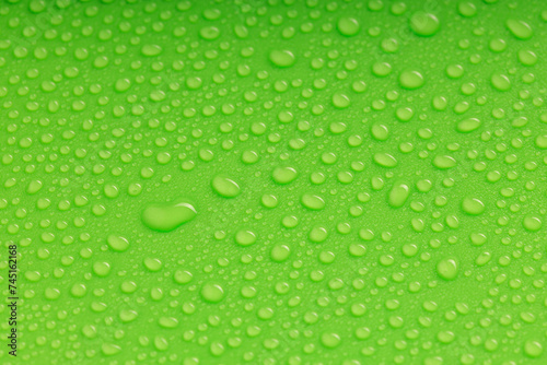 water droplets of various sizes on a green surface