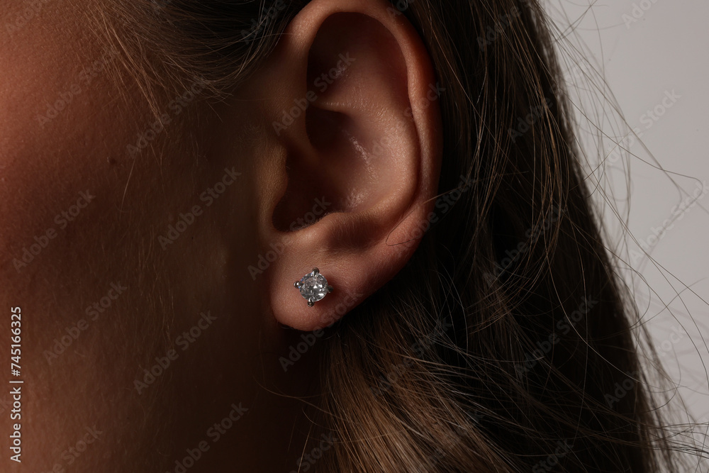Beautiful young girl with fresh healthy skin. Woman advertise ear-rings. White background. Earrings closeup. Blond european woman with long hair with big lips, pretty smile. Cosmetology, scincare Beautiful young girl with fresh healthy skin. Woman advertise ear-rings. White background. Earrings closeup. Blond european woman with long hair with big lips, pretty smile. Cosmetology, scincare