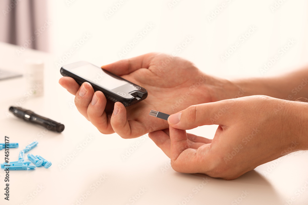 Man using glucometer, checking blood sugar level Man using glucometer, checking blood sugar level
