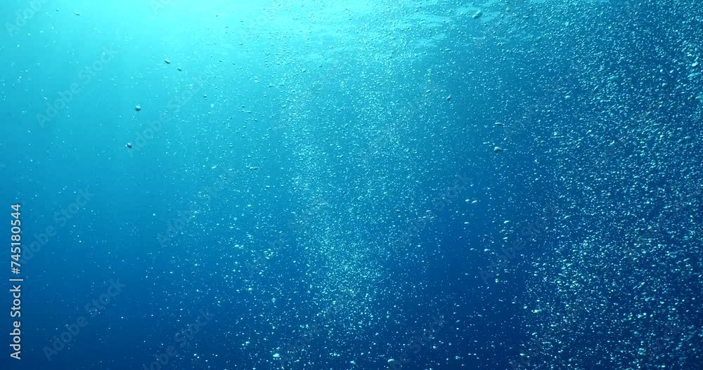 bubbles slow motion underwater coming up to surface with sun beams scenery dark blue backgrounds