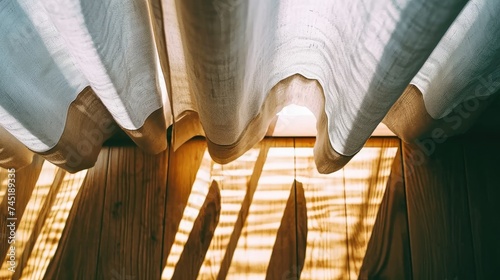 Curtains on the terrace of a wooden house in the rays of the setting sun