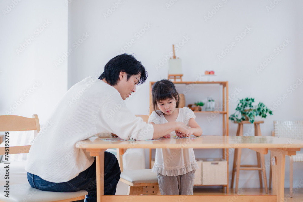 パパと一緒にパズルゲームをする小さな女の子 パパと一緒にパズルゲームをする小さな女の子