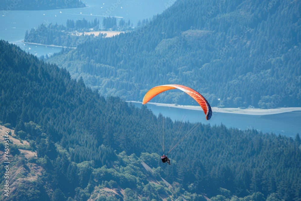 Witness a thrilling sight as a person gracefully paraglides through the sky over majestic mountain peaks, with a serene lake in the background