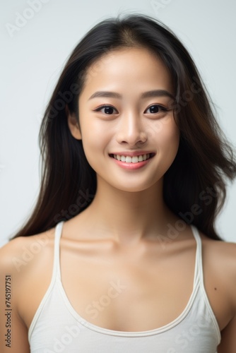A woman with long black hair smiling at the camera. Suitable for various projects
