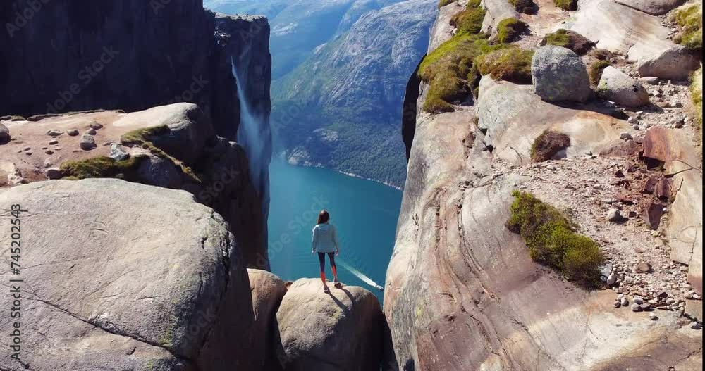 Kjeragbolten, Lysefjord. Norway. Tourist on the stone, famous boulder in Kjerag above Lysefjord in Norway