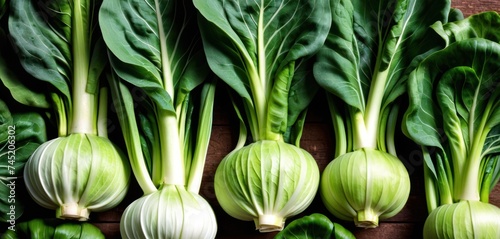 a group of green vegetables sitting on top of a wooden table next to a pile of green leafy vegetables. photo