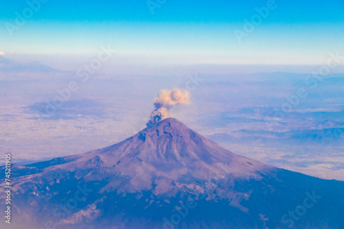 Flying airplane over Mexico Clouds Sky Volcanoes Mountains City desert. © arkadijschell