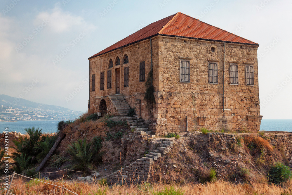 View of the old traditional Lebanese stone house over the Mediterranean sea in Byblos, Lebanon. The house is part of the ancient archaeological complex located next to it.