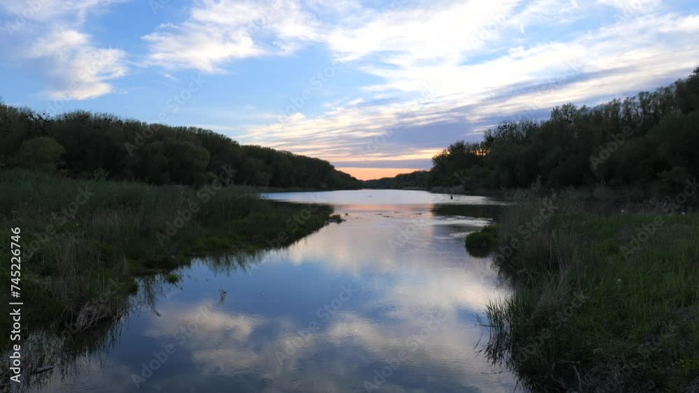River Flowing in a Wetlands Forest Wilderness Landscape in the Evening after Sunset with Orange Sky River Flowing in a Wetlands Forest Wilderness Landscape in the Evening after Sunset with Orange Sky