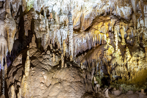 Prometheus Cave Natural Monument - largest cave in Georgia with hanging stone curtains, stalactites and stalagmites, colorful illuminated rock formations. photo